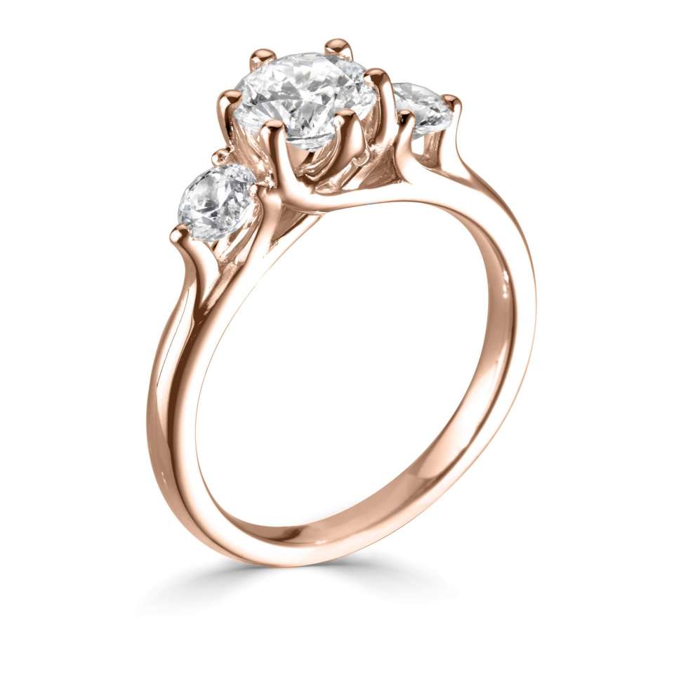 AN ELEGANT ROUND THREE STONE RING WITH PLAIN SHOULDERS AND SIX CLAW CENTRE.